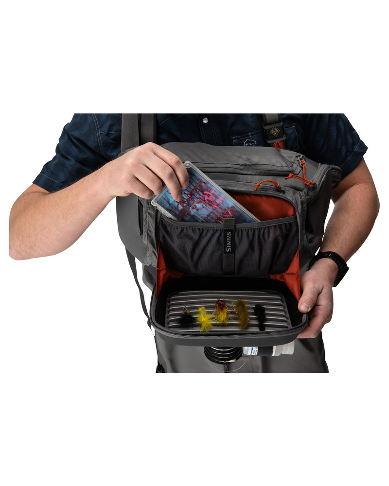 Simms Freestone® Sling Pack featuring a durable design, multiple compartments, and adjustable strap, ideal for carrying fishing essentials securely and comfortably during outdoor excursions.