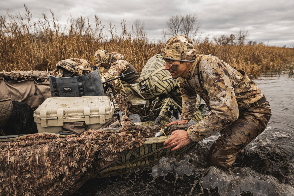 Waterfowl hunters in a marsh at dawn